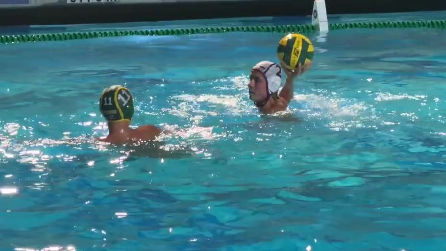 A Whitney player holds the ball high with a Kingsburg defender in front.